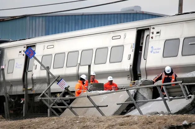 Emergency personnel look over the site of a fatal train collision in Westbury, N.Y.